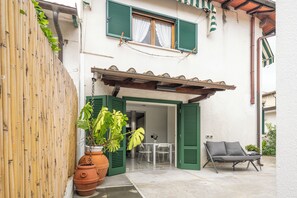 A patio with a table and chairs, a sofa, and a potted plant. - Two-room apartment in Forte dei Marmi Centro (Forte dei Marmi)