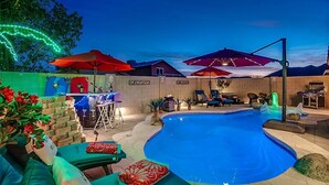 An outdoor pool area with lounge chairs, umbrellas, and a bar. - Spacious 8-bedroom house in phenomenal Glendale with AC and gym (Glendale)
