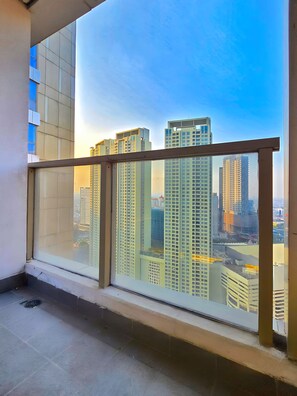 A high-rise building with a glass balcony overlooking a cityscape. - Avenue By SanLiving - 2BR - HubLife Mall (Jakarta)