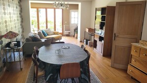 Ein geräumiges Wohnzimmer mit einem runden Tisch, einer Couch und einem Bücherregal.