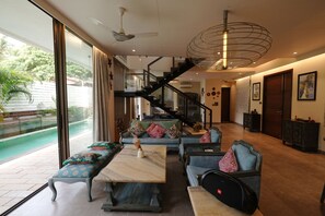 A spacious living area with a large window, a staircase, and a seating area with a coffee table and sofas.