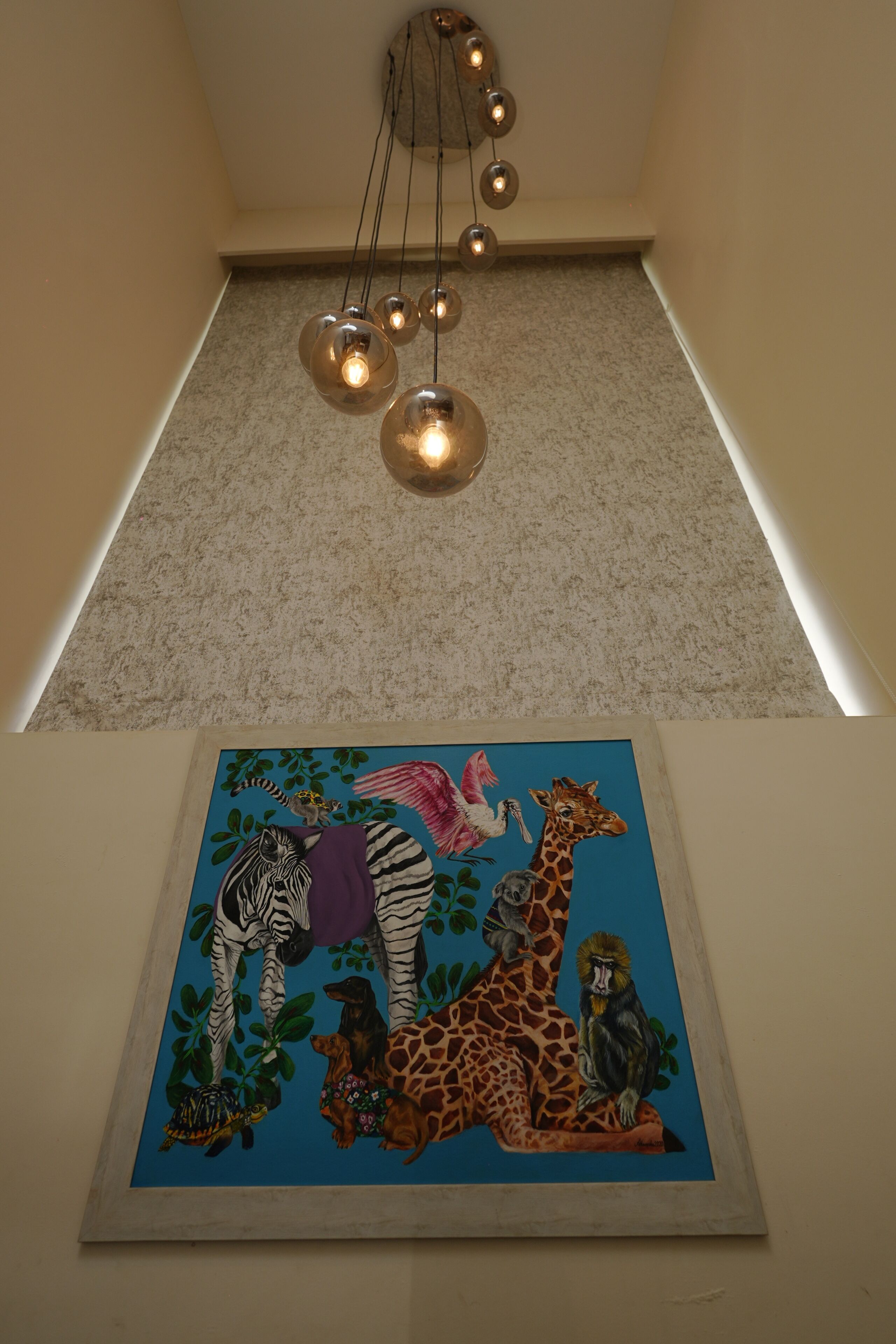 A framed wildlife painting on a wall, a ceiling light fixture, and a carpeted floor.