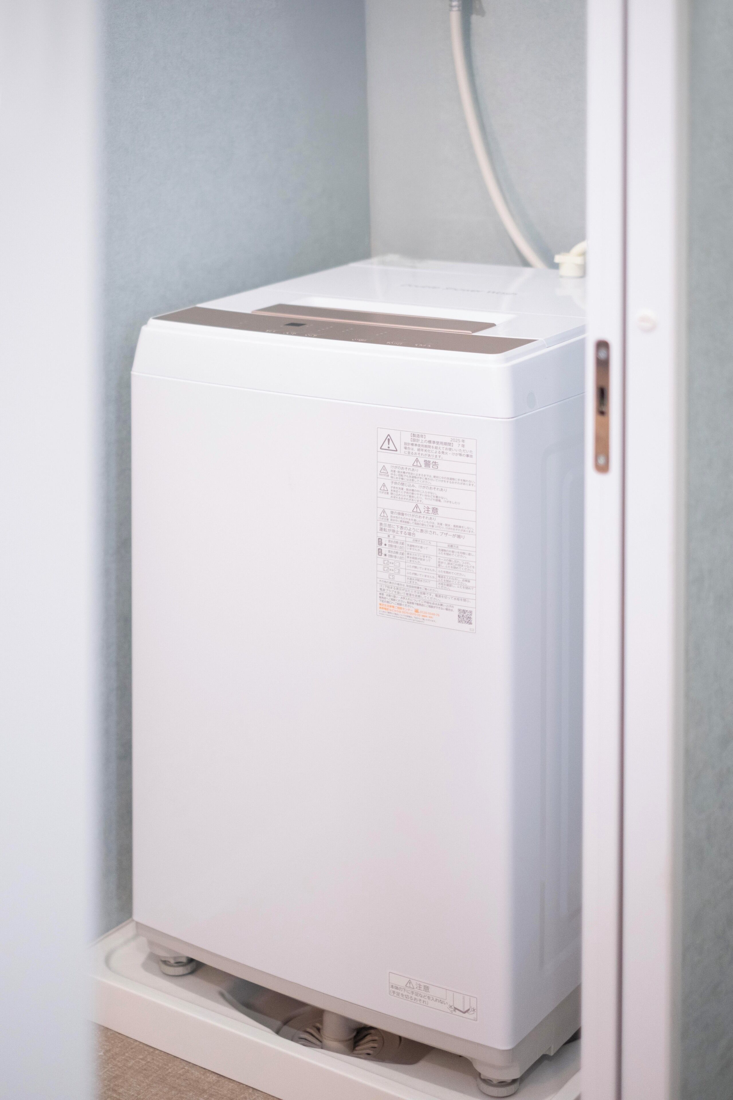 Un radiateur portatif blanc se trouve dans une pièce dont le mur est d’un bleu clair et le cadre de porte est blanc.
