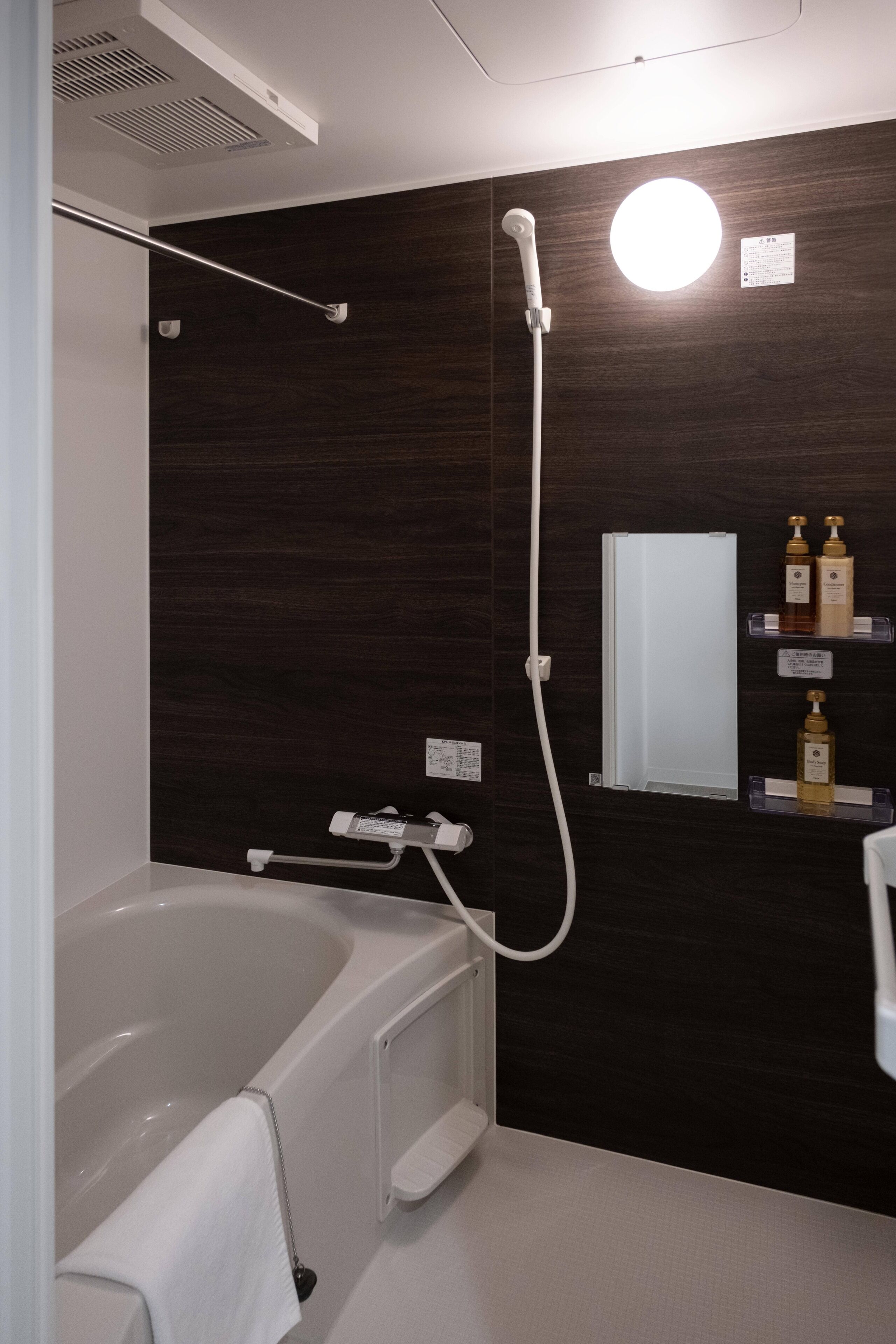 Un baño moderno con bañera, ducha y tocador con artículos de aseo.