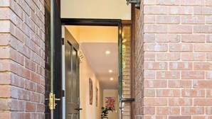 A brick exterior entrance with a door, a potted plant, and a hallway leading inside. - Character & Charm 3BR home - free wine (Adelaide)