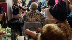A group of people playing string instruments in a room with a view of a street outside. - Accomodation in House (Kinvara)