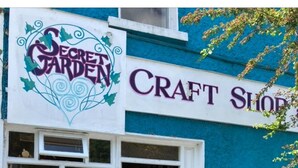 A craft shop with a sign reading "Secret Garden Craft Shop" and a display window with various items. - Accomodation in House (Kinvara)