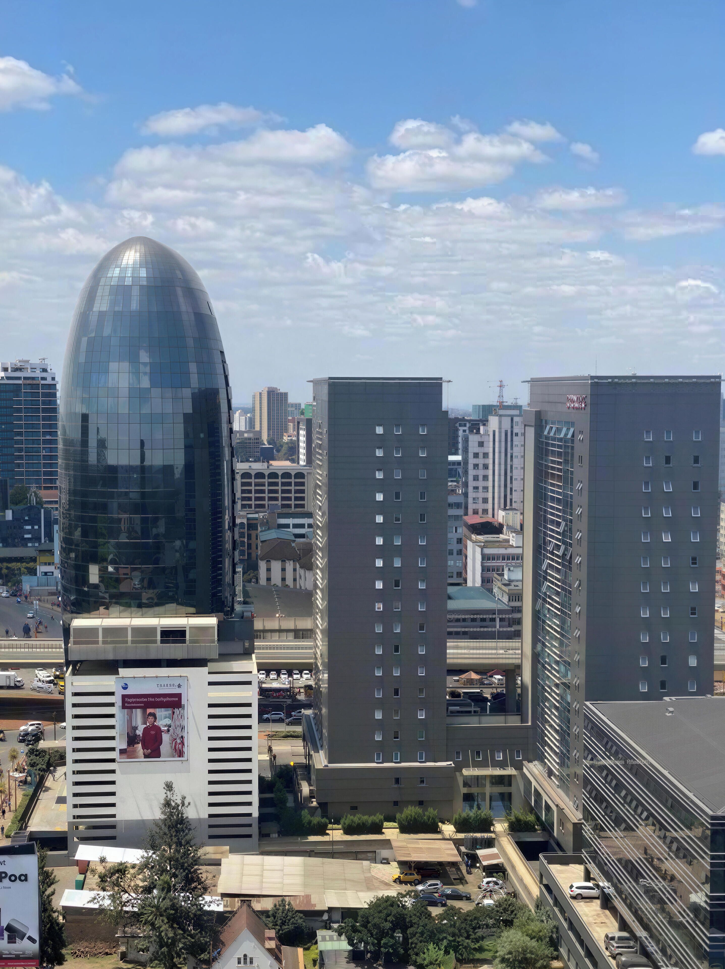 Un paysage urbain avec des bâtiments modernes, dont une structure remarquable en forme de dôme de verre et plusieurs immeubles de grande hauteur.