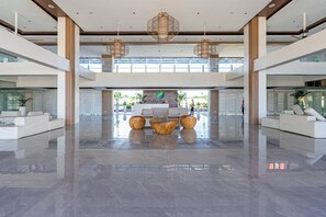 A spacious lobby with a reception desk, modern furniture, and large windows. - Cozy and Nature-Inspired Studio Unit (Lapu-Lapu)