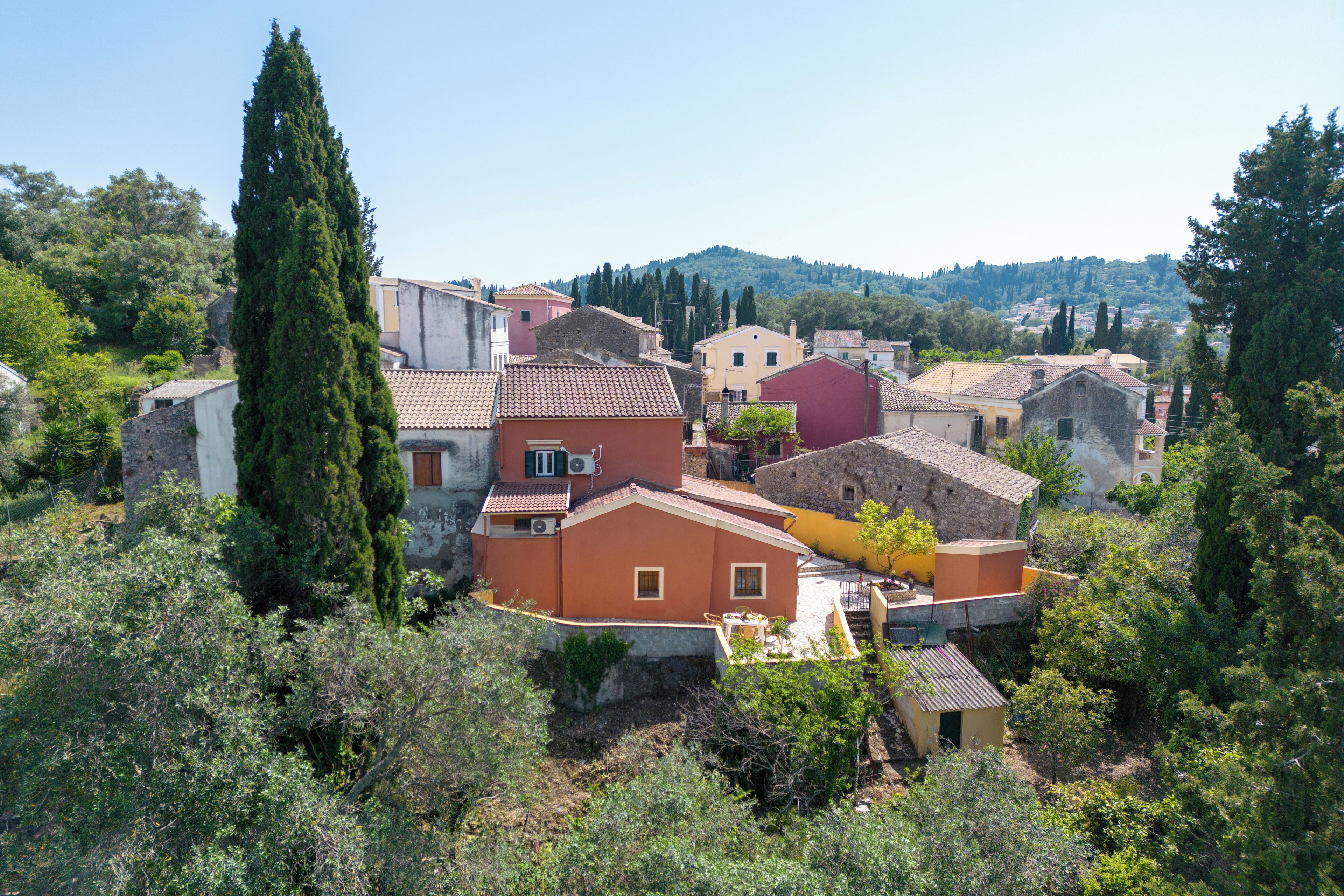 A traditional village with stone buildings, a prominent church, and lush greenery.