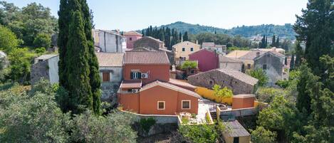 A traditional village with stone buildings, a prominent church, and lush greenery.