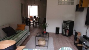 A living room with a sofa, a coffee table, a television, and a bookshelf. - Apartment in the historic center (Camaiore)