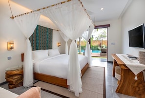 Un dormitorio con cama con dosel, televisor, vista a la piscina y una mesa de madera.