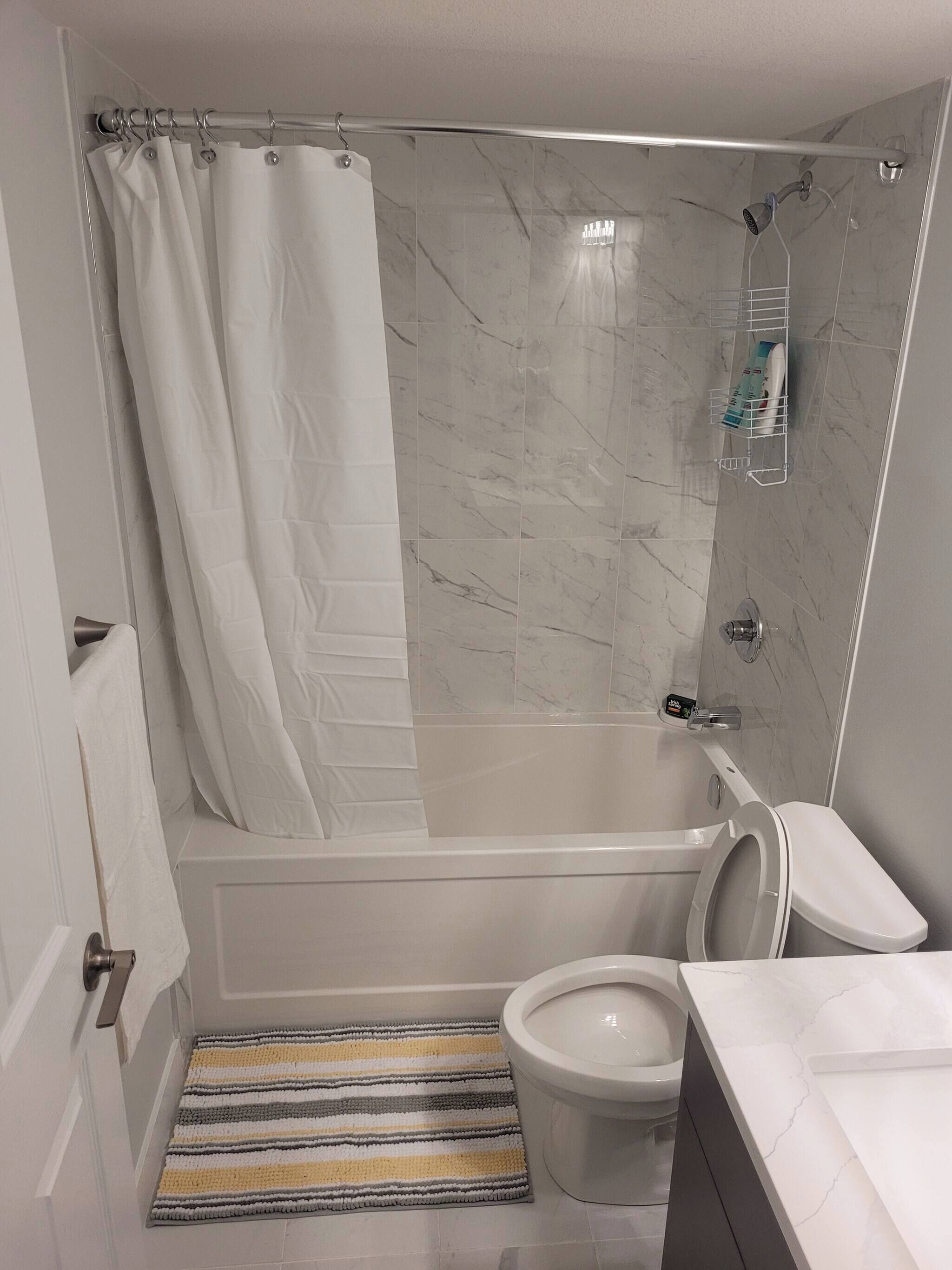 A bathroom with a shower, toilet, and sink.