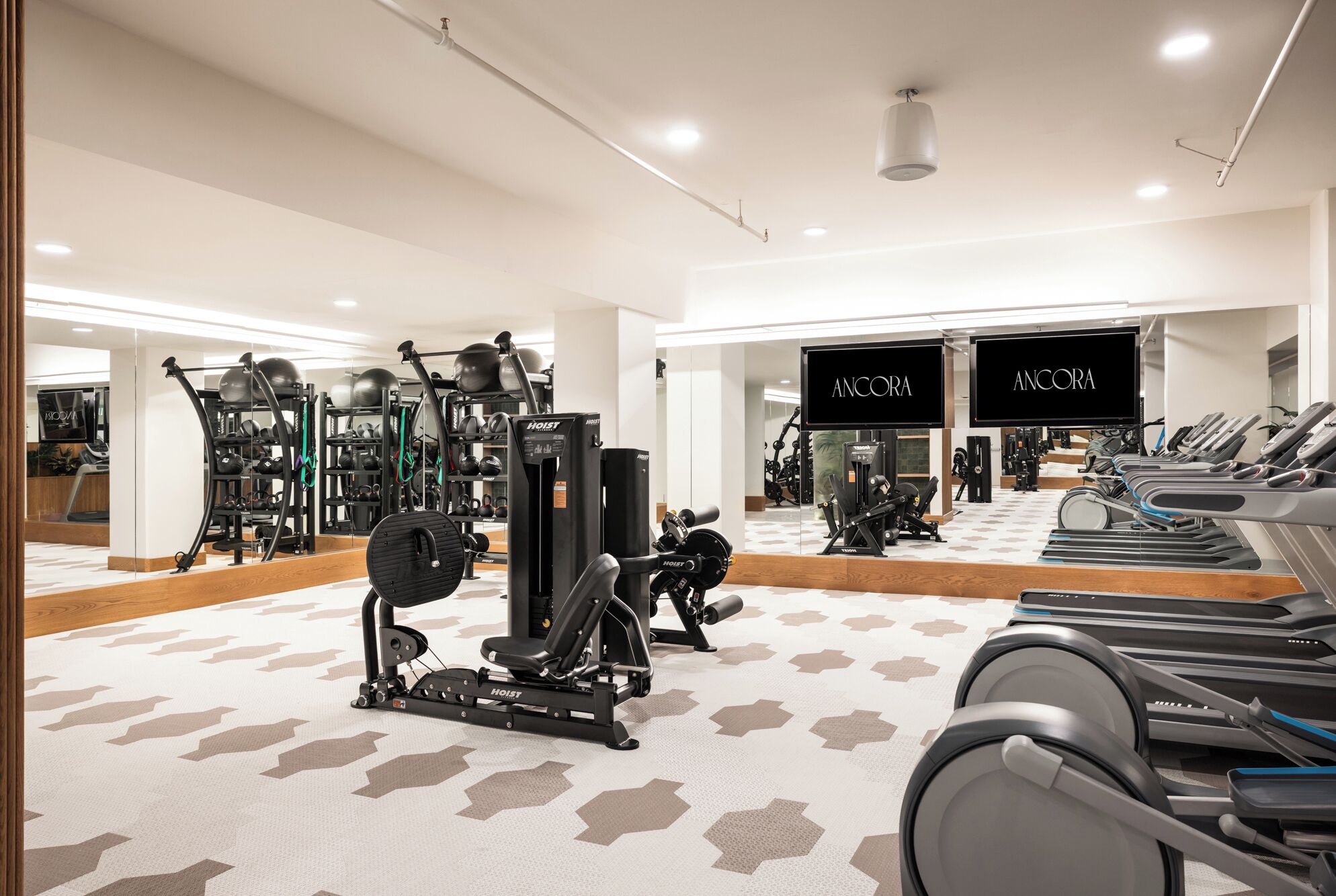 A gym with treadmills, weight machines, and exercise balls.