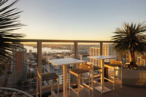 A high-rise balcony with a city view, two tables, and chairs. - Sky Lounge + Gym + Pool + Spa | Downtown Little Italy | Ancora by AvantStay (San Diego)