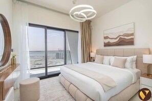 Ein modernes Hotelzimmer mit einem großen Bett, Blick auf die Stadt durch raumhohe Fenster, einem runden Spiegel und einer zeitgemäßen Leuchte.