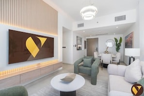 Luxury-Apartment, Balkon, Stadtblick | Wohnbereich | 65-Zoll-Smart-TV mit Kabelempfang
