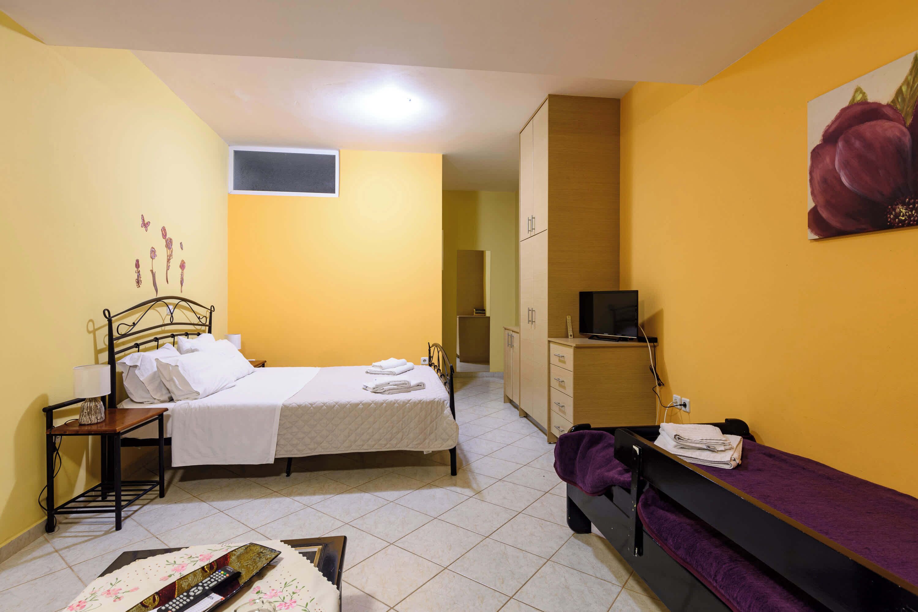 Una camera da letto con un letto, un comodino e una TV.