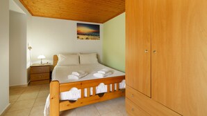 Un dormitorio con cama de madera, una mesita de noche, un armario y un cuadro en la pared.