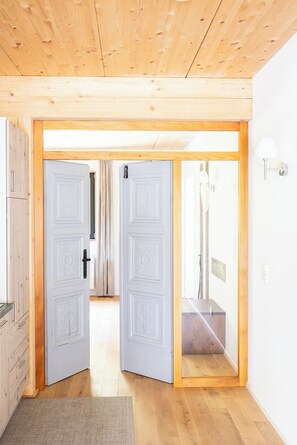 A wooden-paneled room with a door leading to a bathroom. - Kai vacation chalet in Essing—sleeps 2 to 5 people, ideal for families! (Essing)