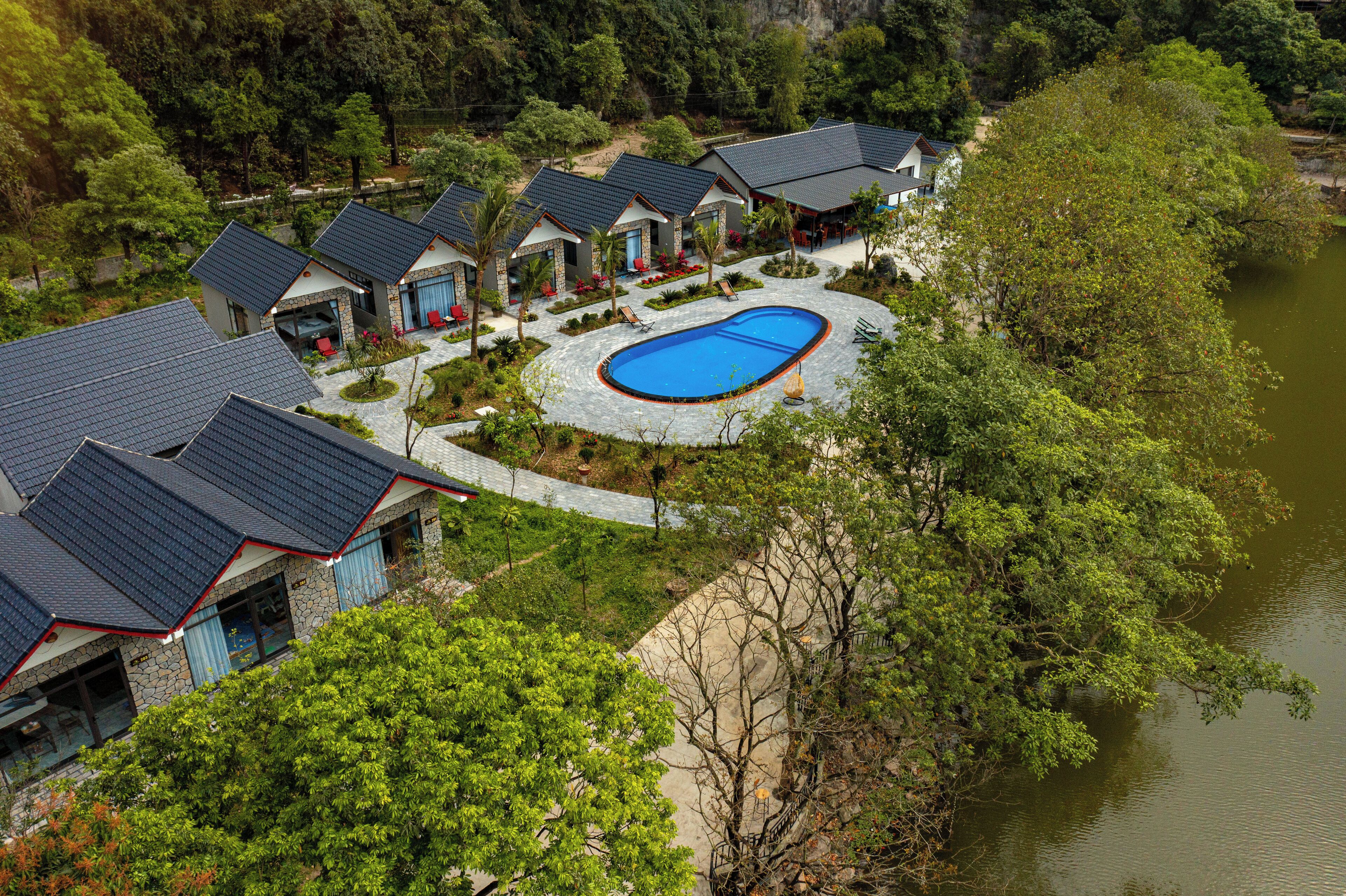 A resort with multiple buildings, a swimming pool, and a lake.