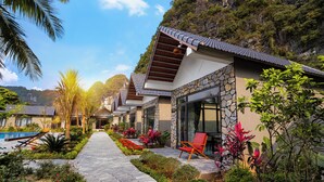 A resort with a stone pathway, outdoor seating, and a pool.