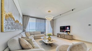 Una sala de estar moderna con un sofá modular, una mesa de centro y un televisor de pantalla plana.
