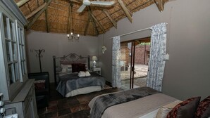 A bedroom with two beds, a ceiling fan, a window with curtains, and a view of the outside. - SUN DOWN LODGE & CONFERENCE (Maletswai)