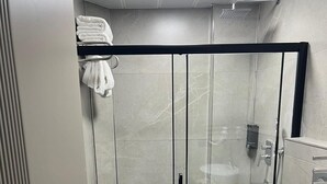 Ein modernes Badezimmer mit einer Duschkabine, einer Toilette und einem Waschbecken.