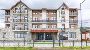 Een hotel met meerdere verdiepingen, een gevel van steen, balkons en een bord met daarop de vermelding dat het een hotel is.