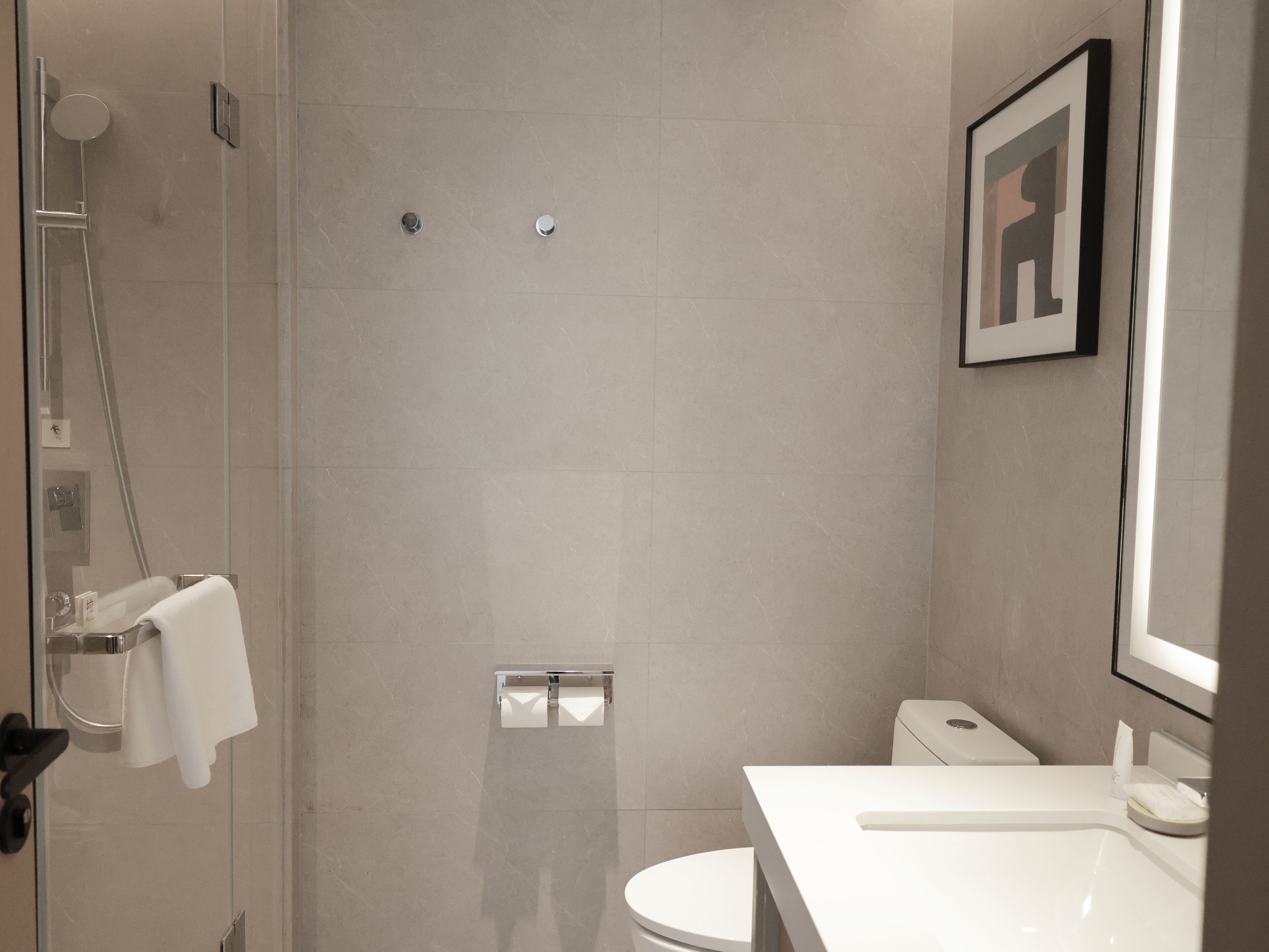 Un baño moderno con ducha, inodoro y lavamanos.