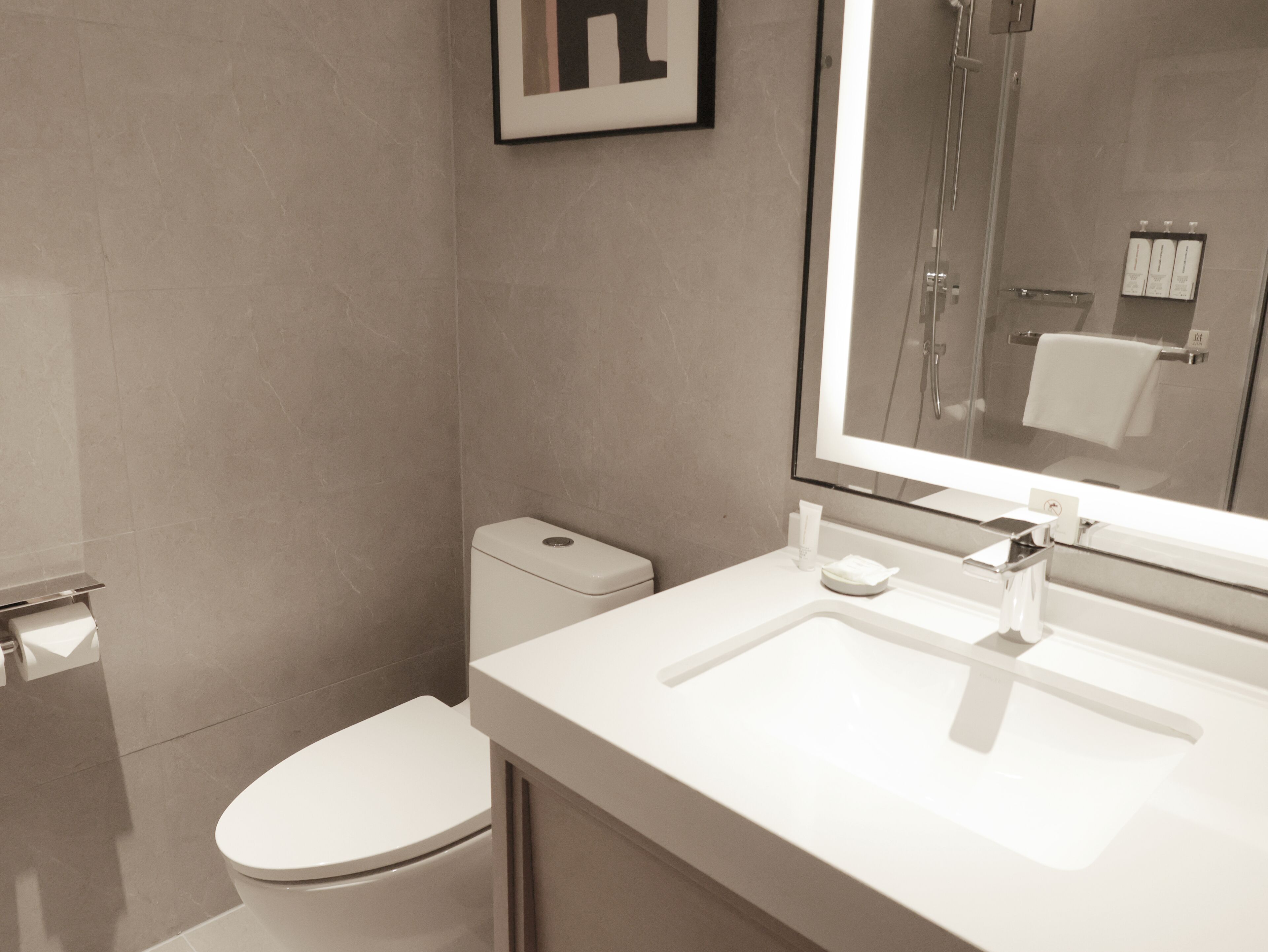 Un baño moderno con inodoro, lavamanos y ducha.