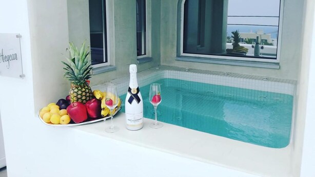 Ein Poolbereich mit einer Champagnerflasche, Obst und zwei Gläsern.