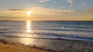A beach with a sunset over the ocean. - A refuge for two between orchard and sea in Valencia, located in P.N.de lálbufera (Valencia)