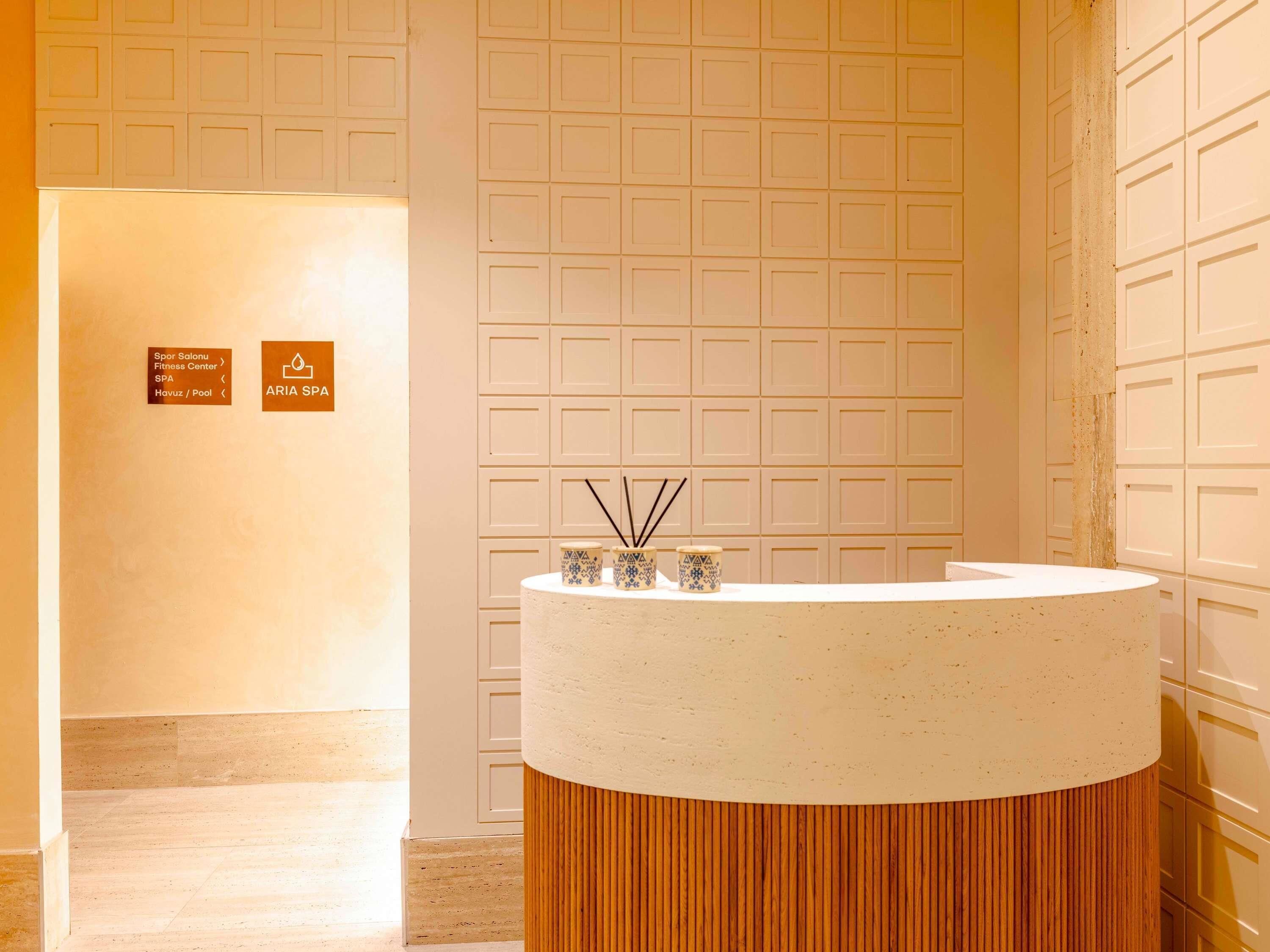 A spa area with a reception desk, a wall with a grid pattern, and a wooden floor.
