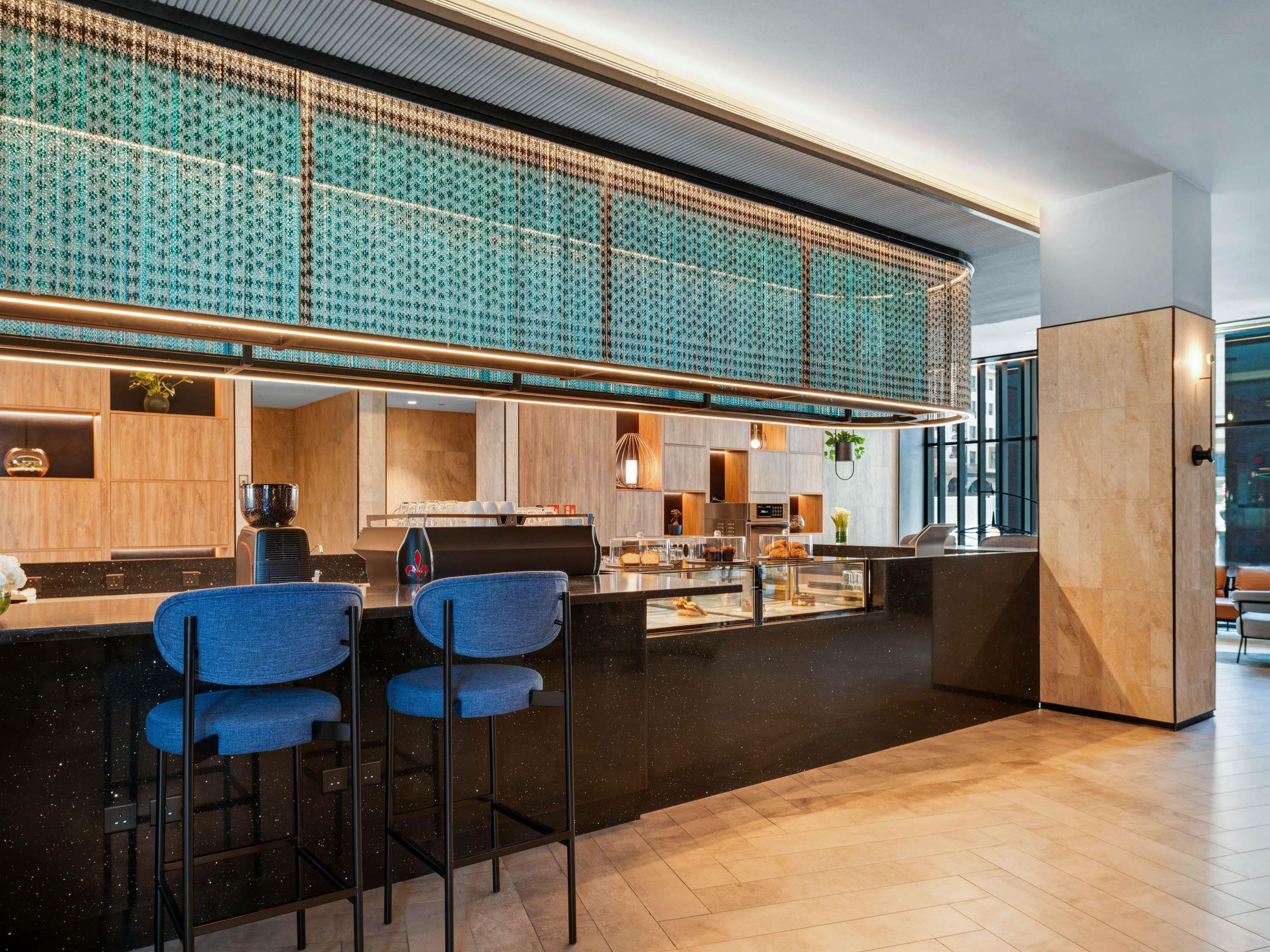 A modern bar area with a high ceiling and patterned wall.