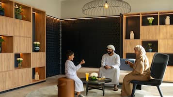 Un intérieur moderne avec des étagères en bois, une table basse ronde et un luminaire suspendu.