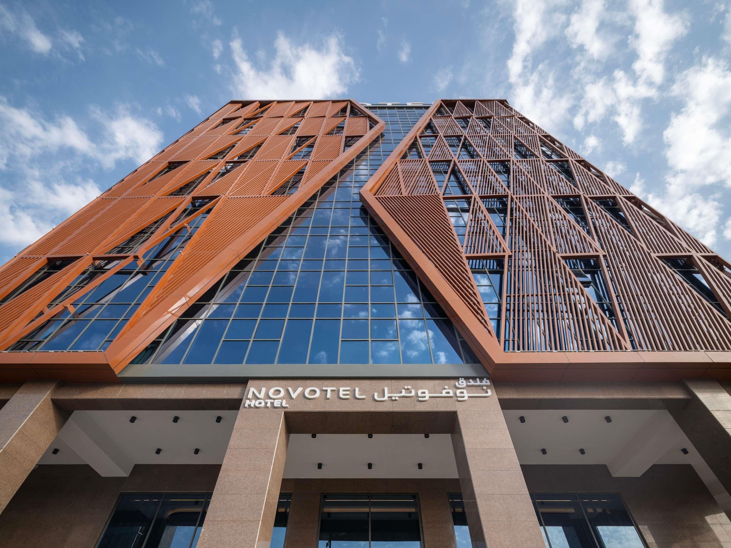 A modern hotel building with a prominent geometric facade and large windows.