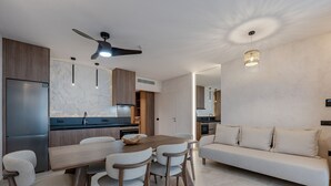 A modern kitchen with a built-in refrigerator, wooden cabinets, and a dining area with a table and chairs. - Domaine–Sun,Luxury Eco Villa, private pool, great view (Chersonissos)