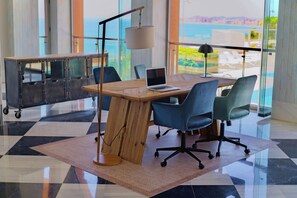 Et moderne kontor med et træskrivebord, to blå stole, en bærbar computer og en lampe.