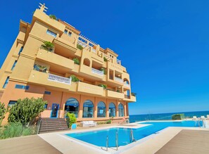 A multi-story hotel with a pool, balconies, and a view of the sea. - Casamaïa Apartments Affiliated by Meliá (Benalmádena)
