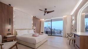 Una habitació d'hotel moderna amb un llit gran, un escriptori i vista a l'exterior.