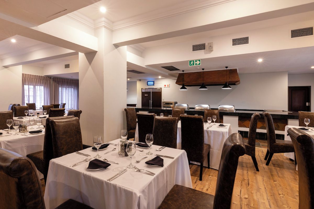 A restaurant with multiple tables, chairs, and a counter.