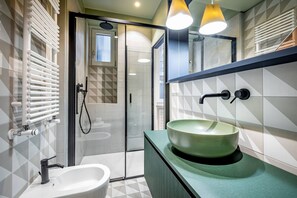 A modern bathroom with a green sink, a bidet, and a glass shower enclosure. - YiD Duomo Suite design in Milan (Milano)