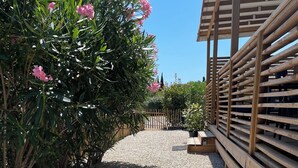 Uma trilha de cascalho leva a uma cerca de madeira com uma estrutura de pérgola.