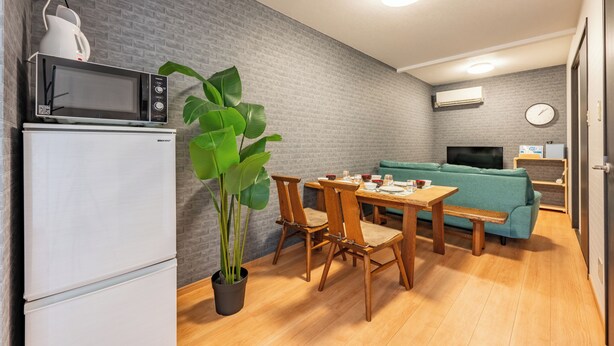 A compact living space with a kitchenette, a dining area, and a seating area. - 外観は古い建物ですが内装はフルリノベーション済みです。TV、無料Wi-Fi、ドライヤー、浴室乾燥機、洗濯機完備。トイレにはウォシュレットも完備しております。 (Nakamichi,Higashinari-ku,Osaka-shi)