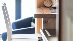 Ein Zimmer mit einem Holztisch, einem Stuhl und einem Fenster.