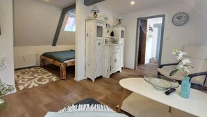 A bedroom with a bed, a dresser, a mirror, and a window. - Lütt Stuuv im historischen Flensburger Hafen (Flensburg)