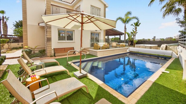 A swimming pool with lounge chairs and a covered patio area. - Rock Azure Villa | Pool & Jacuzzi in Ayia Thekla (Ayia Napa)
